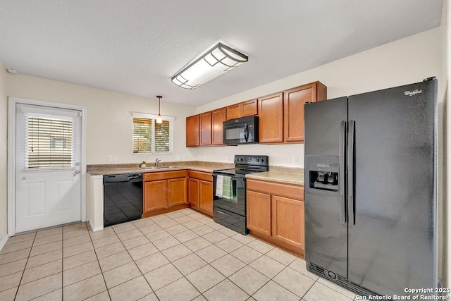 kitchen with light tile patterned flooring, decorative light fixtures, sink, and black appliances