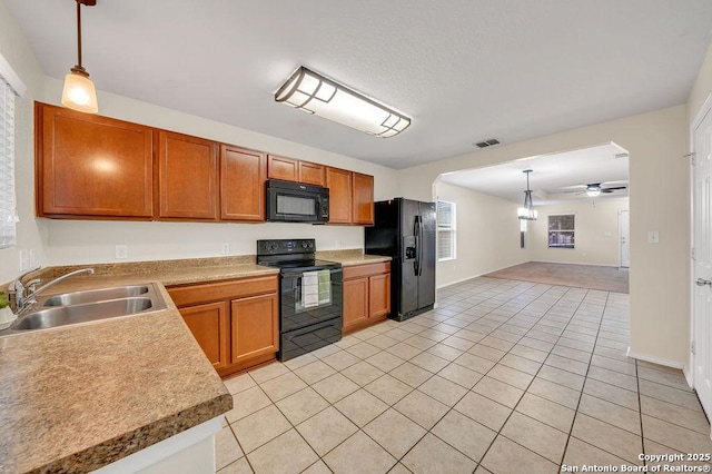 kitchen featuring light tile patterned flooring, sink, decorative light fixtures, ceiling fan, and black appliances