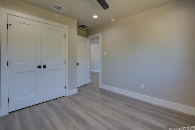 unfurnished bedroom featuring ceiling fan, light wood-type flooring, and a closet