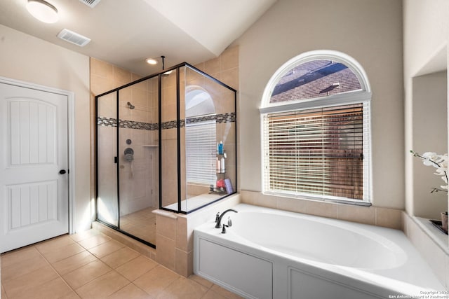 bathroom featuring tile patterned flooring, vaulted ceiling, and separate shower and tub