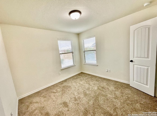 unfurnished room with a textured ceiling and carpet flooring