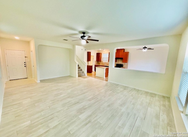 unfurnished living room featuring light hardwood / wood-style floors and ceiling fan