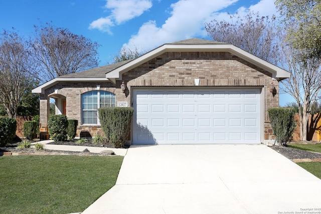 ranch-style home featuring a front lawn, brick siding, driveway, and an attached garage