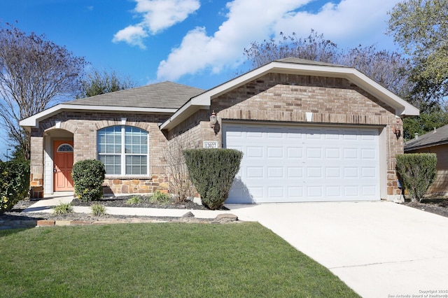 view of front of property featuring an attached garage, driveway, a front lawn, and brick siding