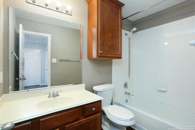 full bath featuring toilet, a textured wall, bathtub / shower combination, and vanity