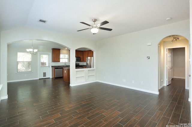 unfurnished living room featuring wood tiled floor, visible vents, baseboards, and ceiling fan with notable chandelier