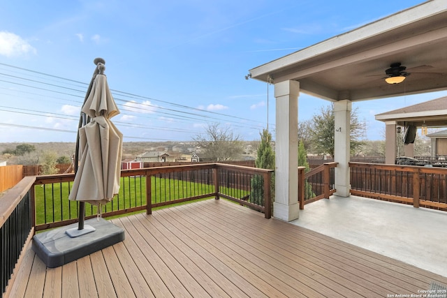 deck featuring ceiling fan and a lawn