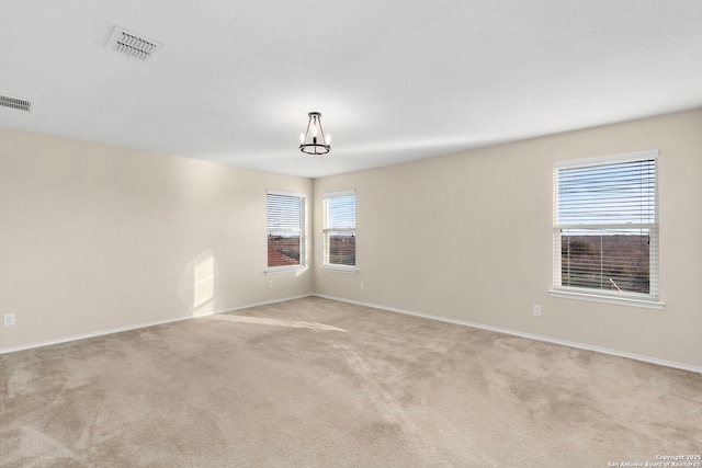 unfurnished room featuring a wealth of natural light and light colored carpet