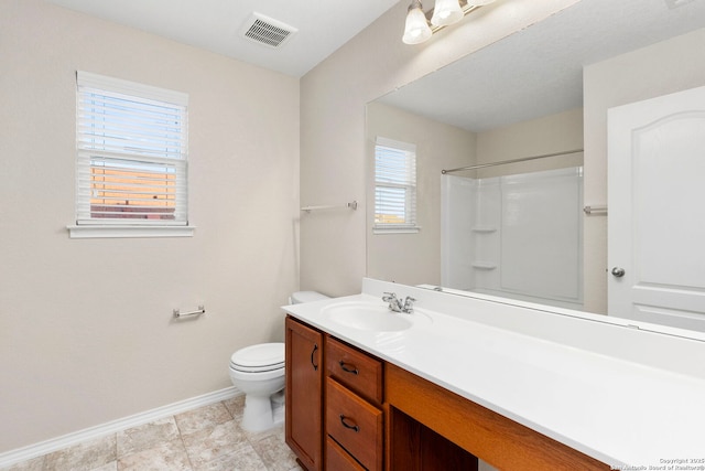 bathroom featuring vanity, a shower, and toilet