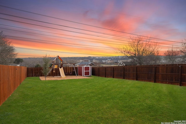 yard at dusk with a shed and a playground