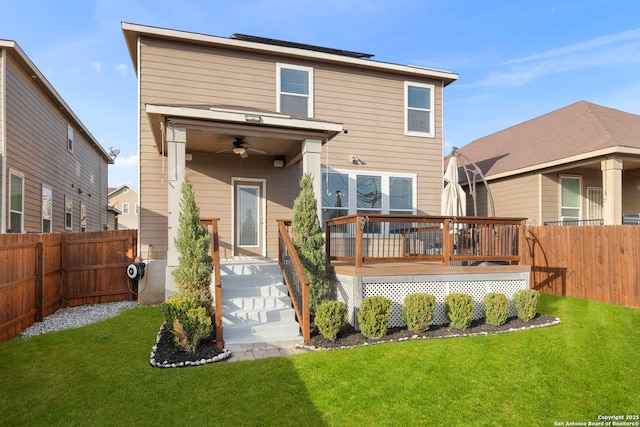 rear view of house with a wooden deck, ceiling fan, and a yard