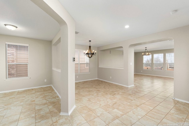 tiled empty room featuring a notable chandelier