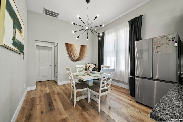 dining space featuring a chandelier and light wood-type flooring