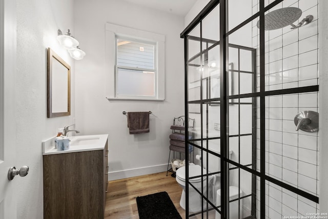 bathroom with vanity, hardwood / wood-style floors, and tiled shower