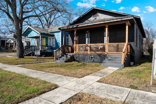 bungalow featuring a front yard and covered porch