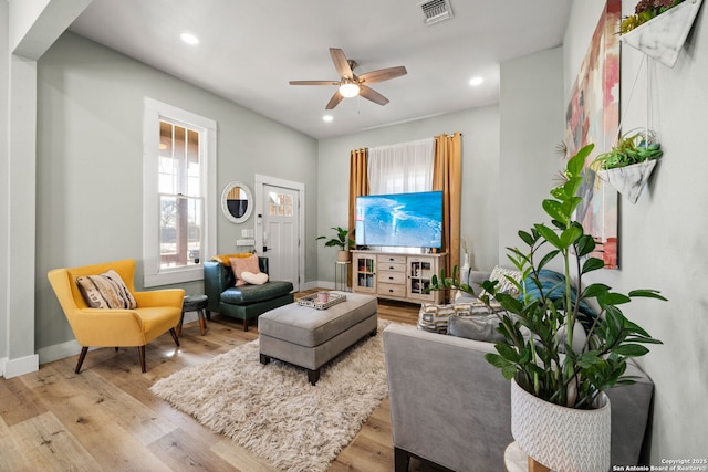 living room featuring light hardwood / wood-style flooring and ceiling fan