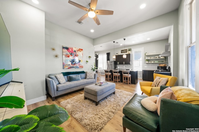 living room featuring ceiling fan and light hardwood / wood-style flooring