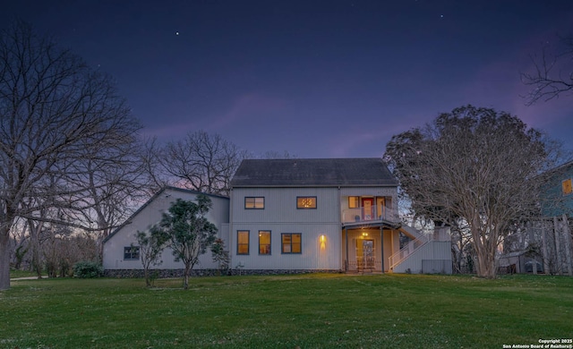 view of front of property featuring a balcony and a lawn