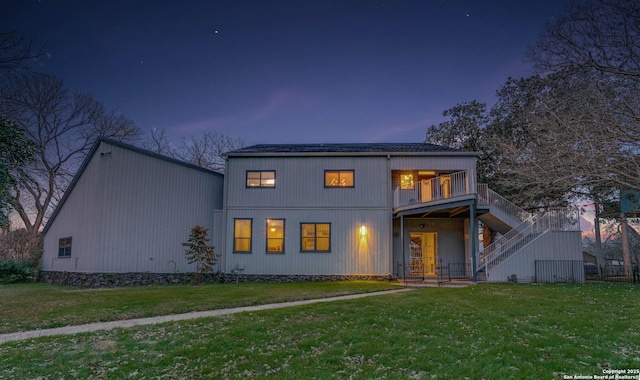 view of front of property featuring a balcony and a lawn