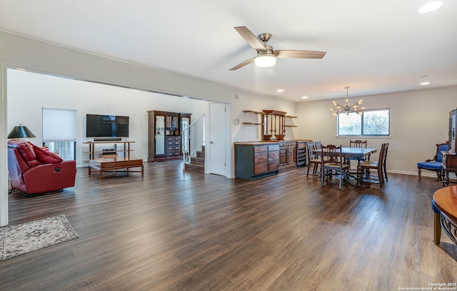 dining space with dark wood-type flooring, ceiling fan with notable chandelier, and beverage cooler