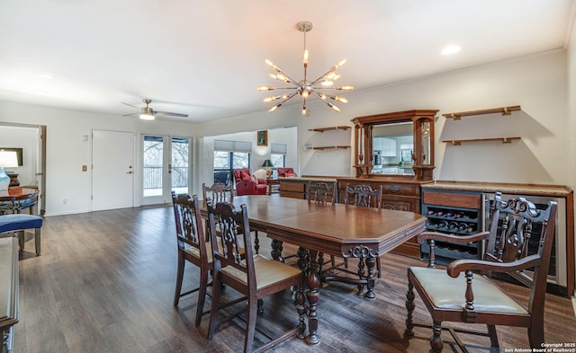 dining room with ceiling fan with notable chandelier and dark wood-type flooring