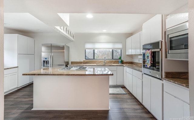 kitchen with appliances with stainless steel finishes, a center island, and white cabinets