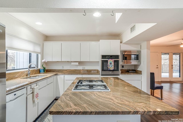 kitchen featuring white cabinetry, sink, stainless steel appliances, and a center island