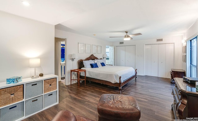 bedroom featuring multiple closets, ceiling fan, and dark hardwood / wood-style flooring
