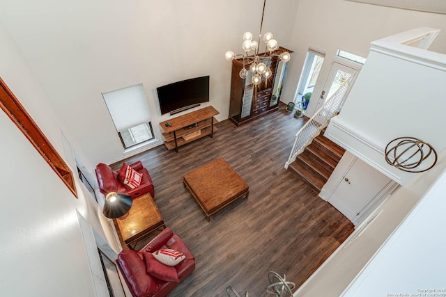 living room featuring a notable chandelier, dark hardwood / wood-style floors, and a high ceiling