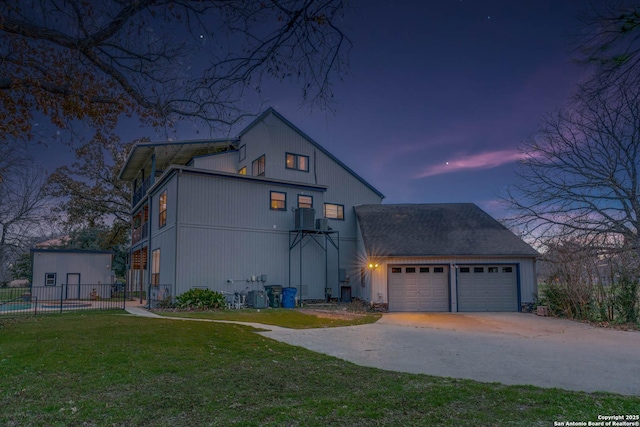 view of front facade featuring a garage, a yard, and central AC unit