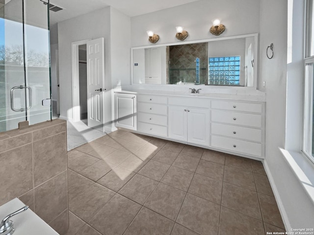 bathroom with tile patterned flooring, vanity, and a shower with door