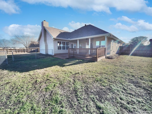 rear view of house featuring a deck and a lawn