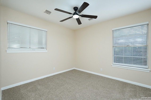 empty room featuring ceiling fan, a healthy amount of sunlight, and carpet flooring