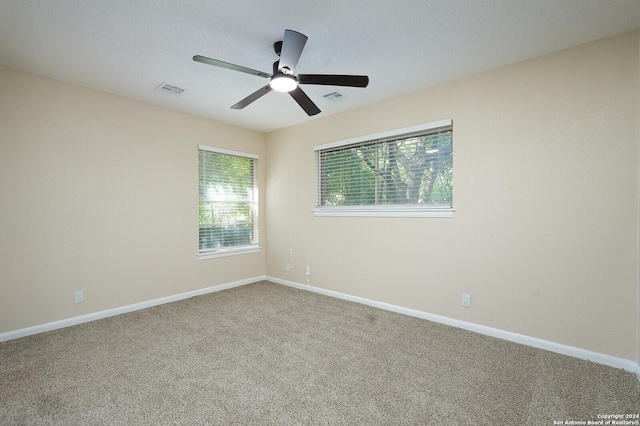 carpeted spare room with ceiling fan