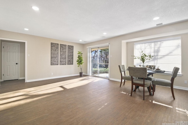 dining space with dark hardwood / wood-style flooring and a textured ceiling