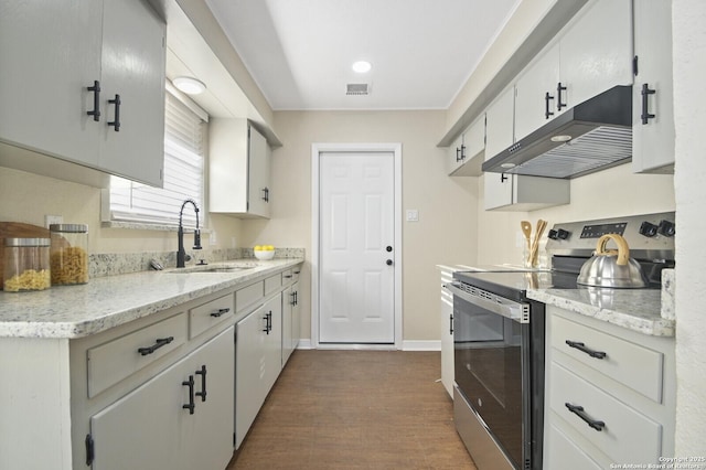 kitchen with stainless steel electric stove, white cabinetry, sink, dark hardwood / wood-style flooring, and light stone countertops