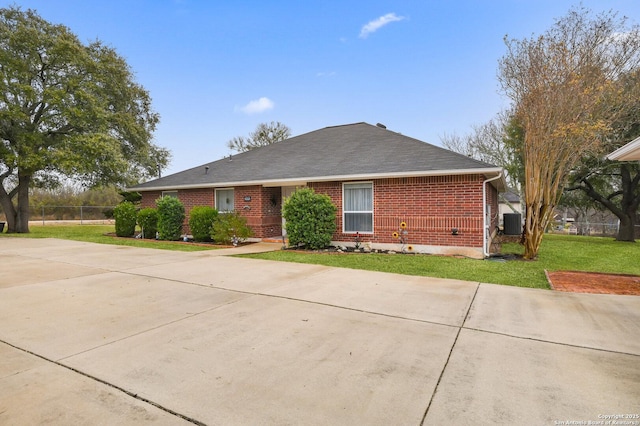 ranch-style house featuring cooling unit and a front lawn