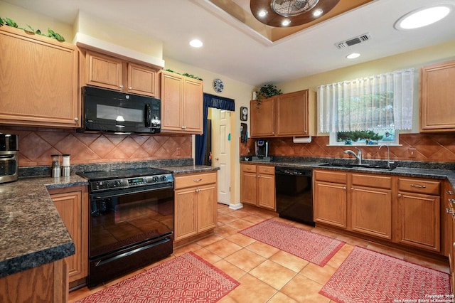 kitchen with sink, light tile patterned floors, black appliances, decorative backsplash, and a raised ceiling