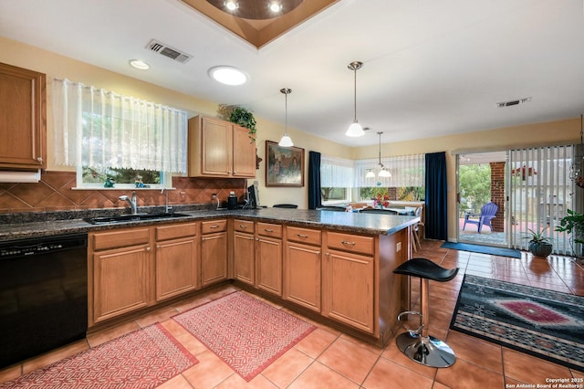 kitchen featuring decorative light fixtures, dishwasher, sink, and kitchen peninsula