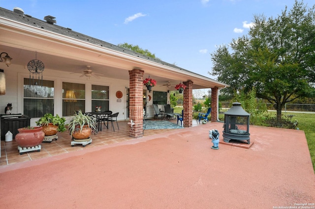 view of patio with ceiling fan and an outdoor fire pit