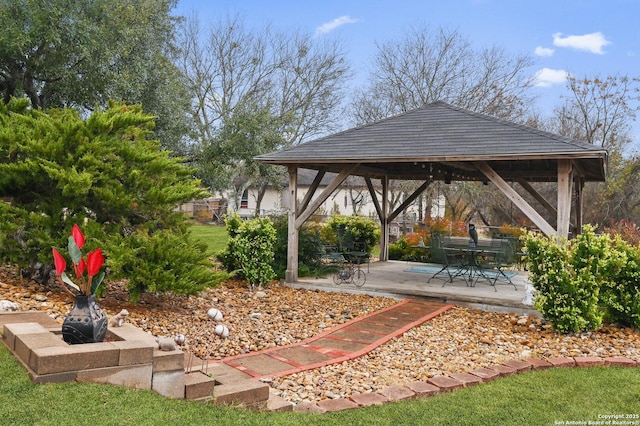 view of community with a gazebo, an outdoor fire pit, and a patio area