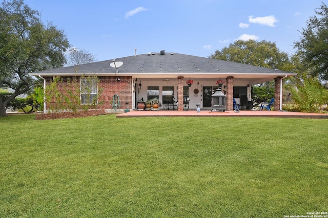 back of property with a yard and a patio