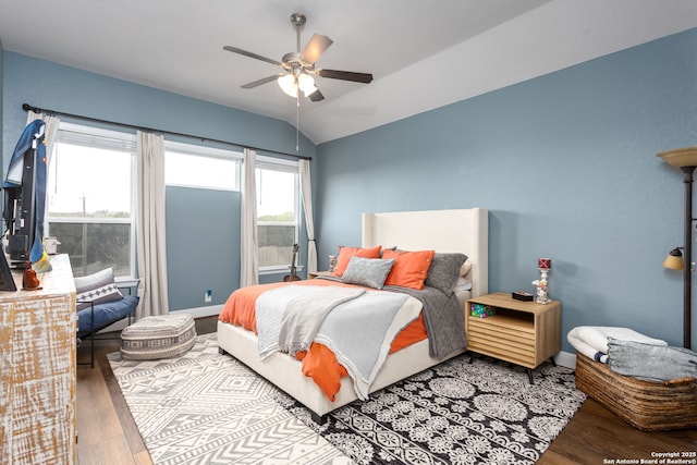 bedroom with ceiling fan, lofted ceiling, and wood-type flooring