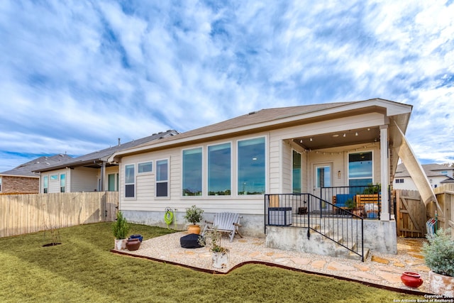 back of house with a yard and a patio