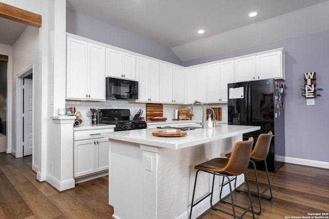 kitchen with white cabinetry, black appliances, dark hardwood / wood-style floors, a kitchen island with sink, and backsplash