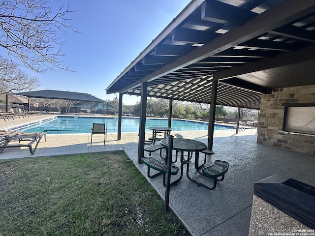 pool featuring a patio, exterior fireplace, and a lawn