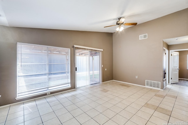 unfurnished room featuring ceiling fan, vaulted ceiling, and light tile patterned floors