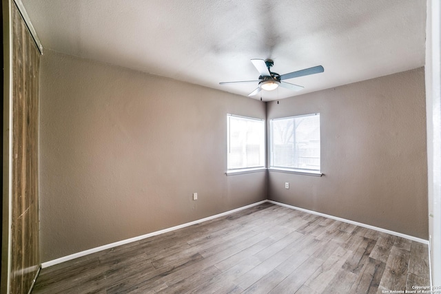 empty room featuring hardwood / wood-style flooring, ceiling fan, and a textured ceiling