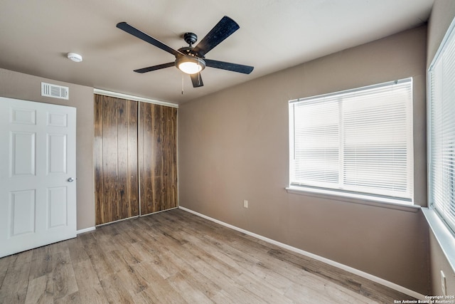 unfurnished bedroom featuring a closet, ceiling fan, and light wood-type flooring