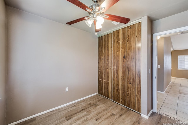 unfurnished bedroom with ceiling fan, a closet, and light hardwood / wood-style flooring